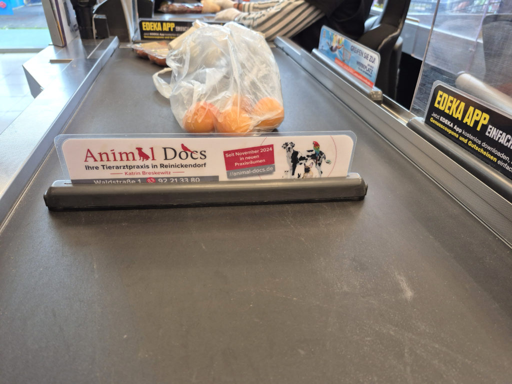 Warentrenner auf einem Kassenband mit Werbung