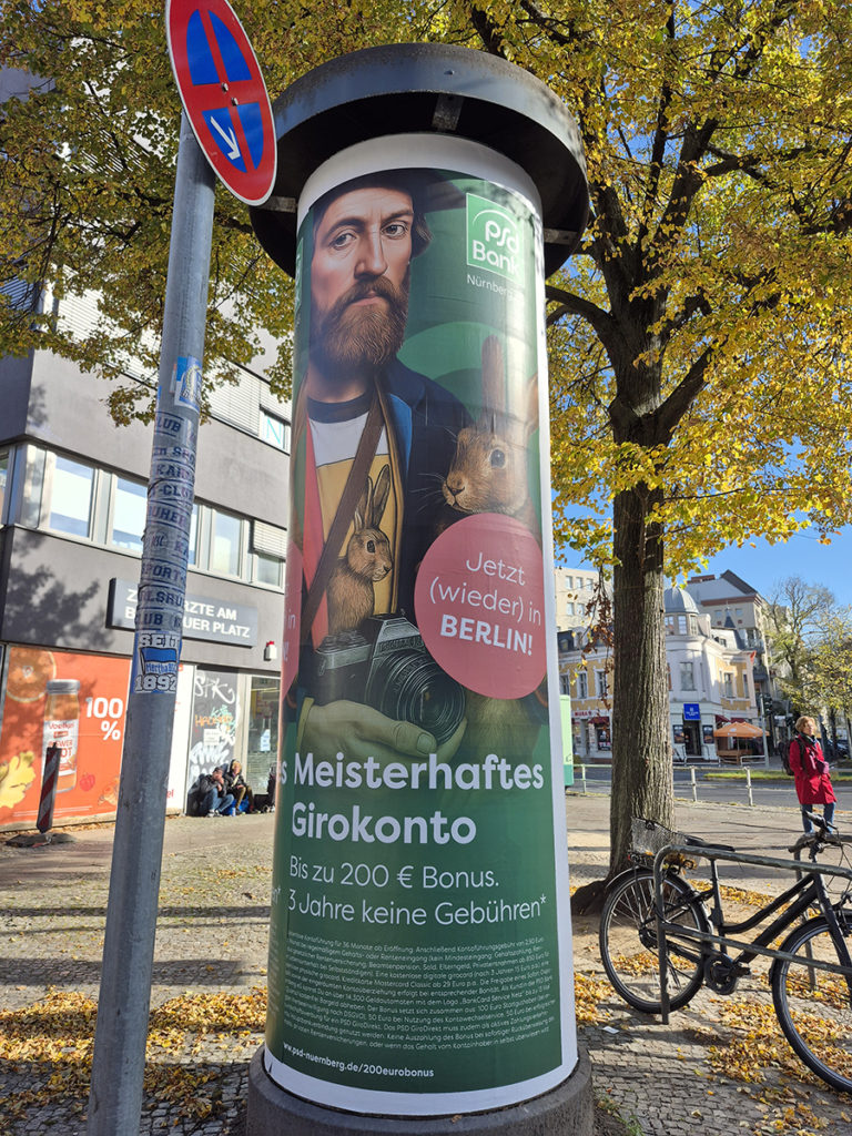 Litfaßsäule mit Plakatwerbung für Girokonto einer Bank