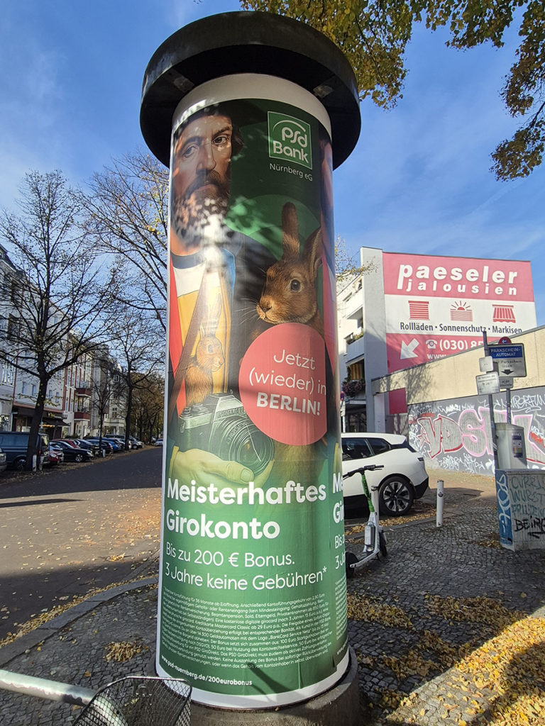 Litfasssäulen Werbung für die PSD Bank, direkt an einer Straße und einem Gehweg für starke Reichweite.
