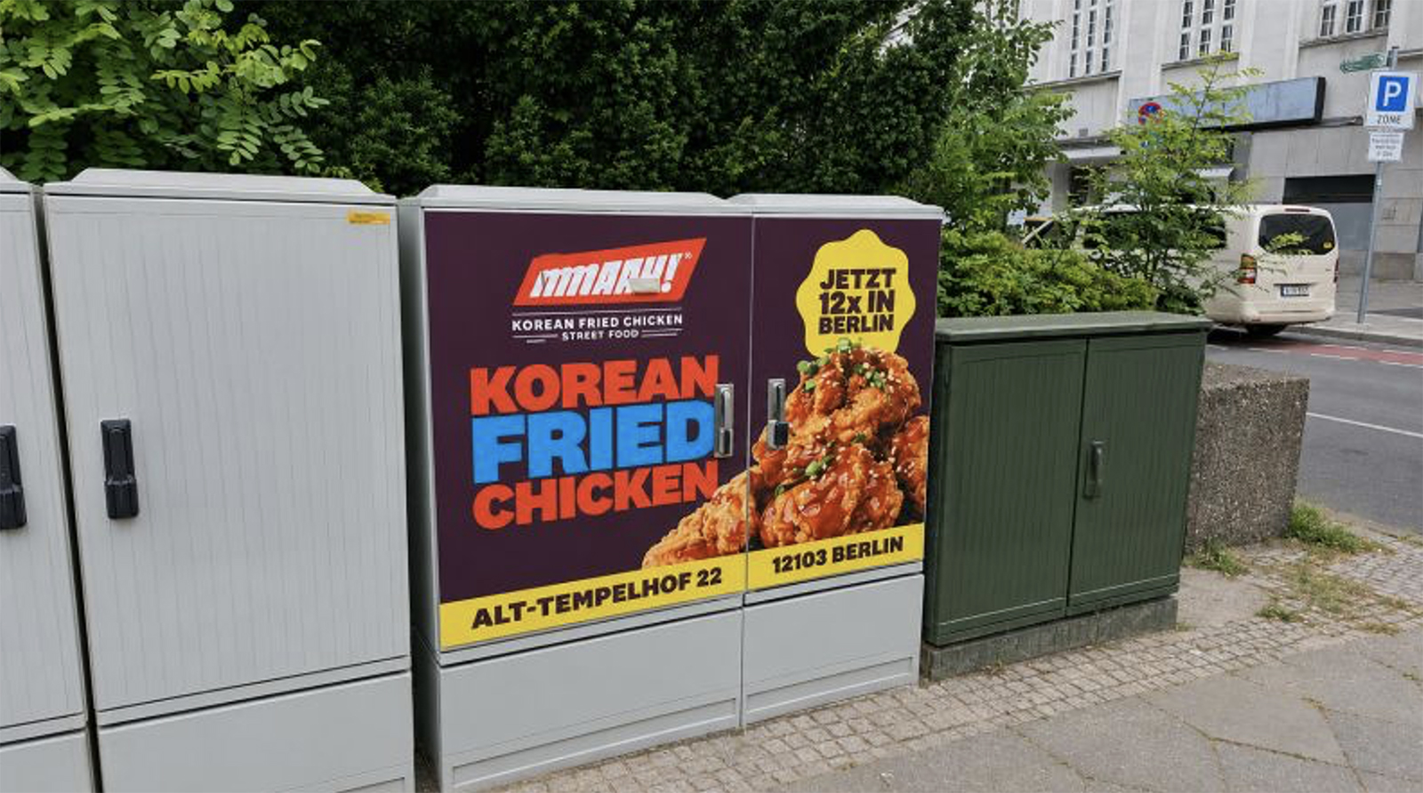 Ein Kasten an einer Straße mit einer Werbung für Koreanisches Essen